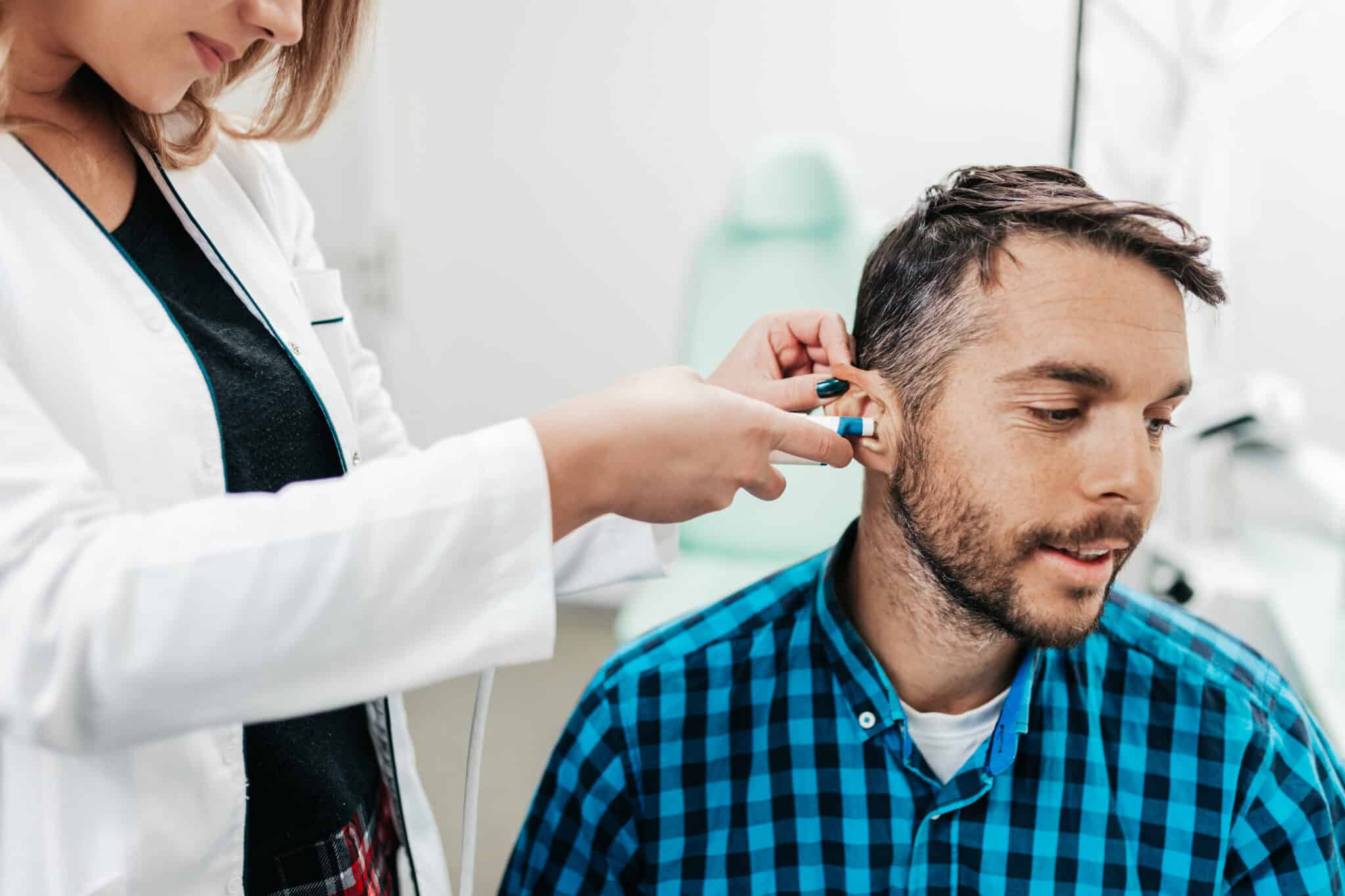 Middle age man at medical examination or checkup at audiologist's office