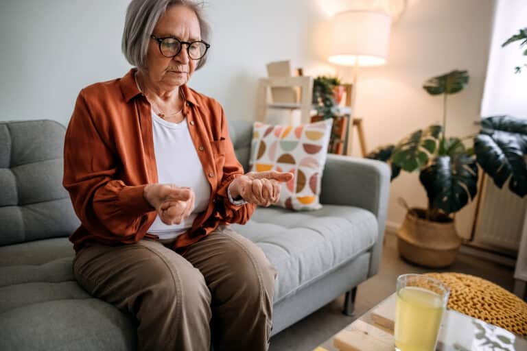 Woman clenching her fists experiencing arthritis