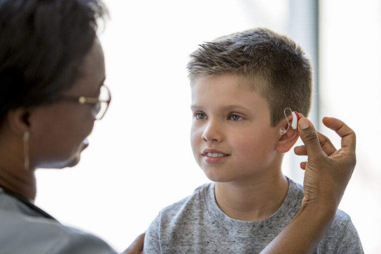 Young boy wears a hearing aid