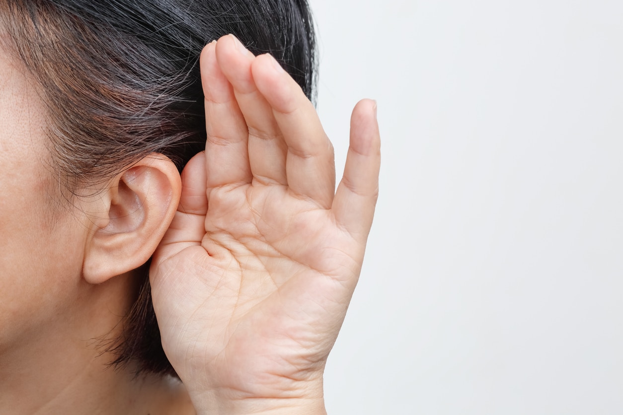 Person holds hand up behind ear